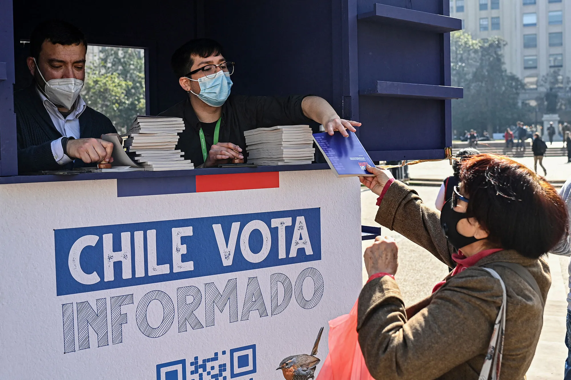 A woman receives a copy of the draft of the new constitution in front La Moneda presidential palace in Santiago.