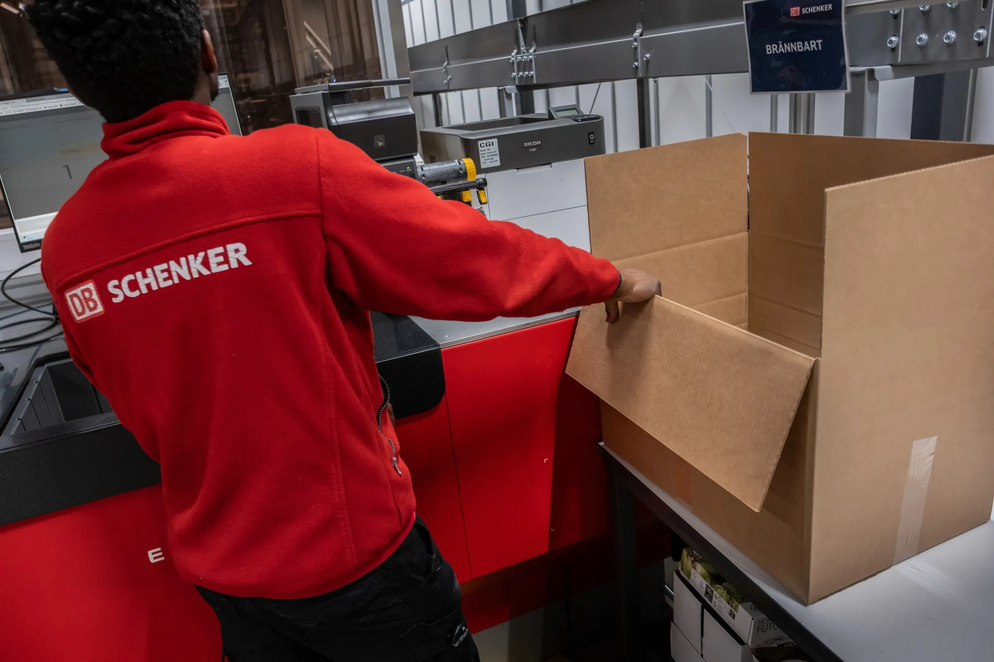 A worker packs a customer's order inside a DB Schenker&nbsp;logistics hub near Gothenburg, Sweden