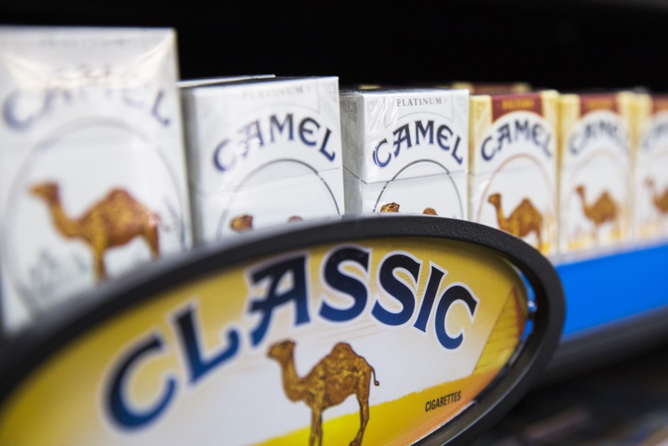 Camel cigarettes are stacked on a shelf inside a tobacco store in New York City.