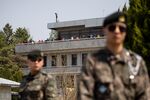 Tourists looking out from the Panmungak pavillion on the North Korean side of the border are seen from the South Korean side in the truce village of Panmunjom in the Demilitarized Zone (DMZ) .