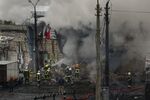 Fire and rescue workers attend a building hit by a missile in central Kyiv on Nov. 23.
