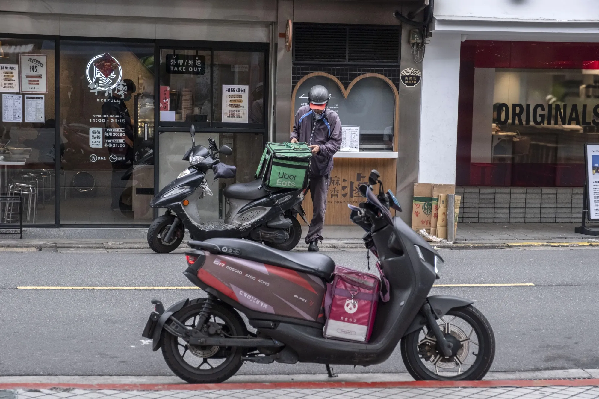 UberEats and Foodpanda food delivery bags on motorcycles in Taipei