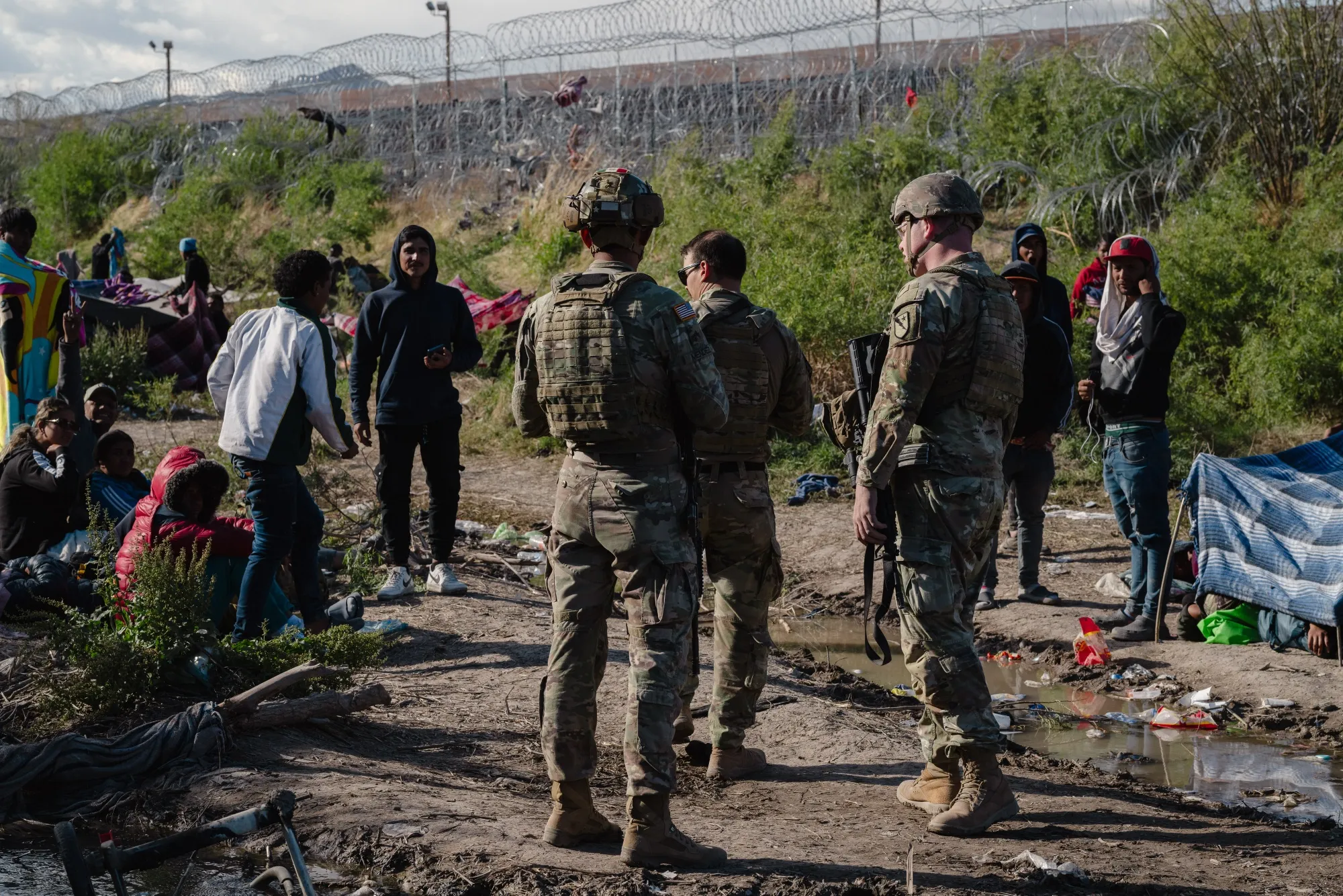 Members of the Texas National Guard walk through an encampment of migrants&nbsp;in El Paso, Texas.