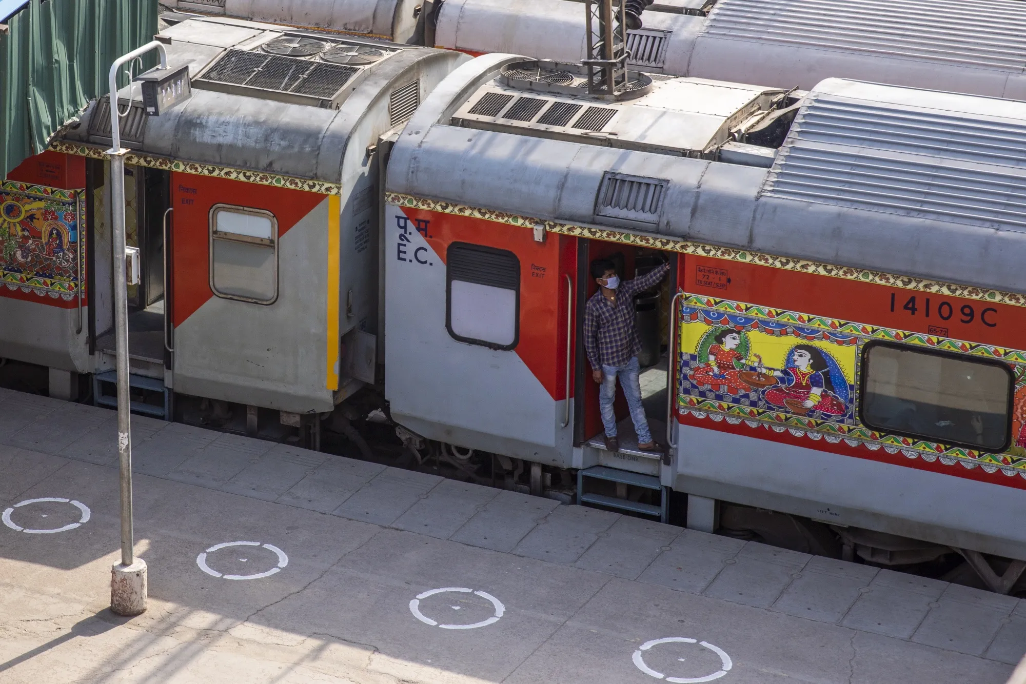 Social distancing markers are displayed on a platform as a man wearing a protective mask stands at a door of a train carriage at the New Delhi Railway station&nbsp;on&nbsp;May 14.