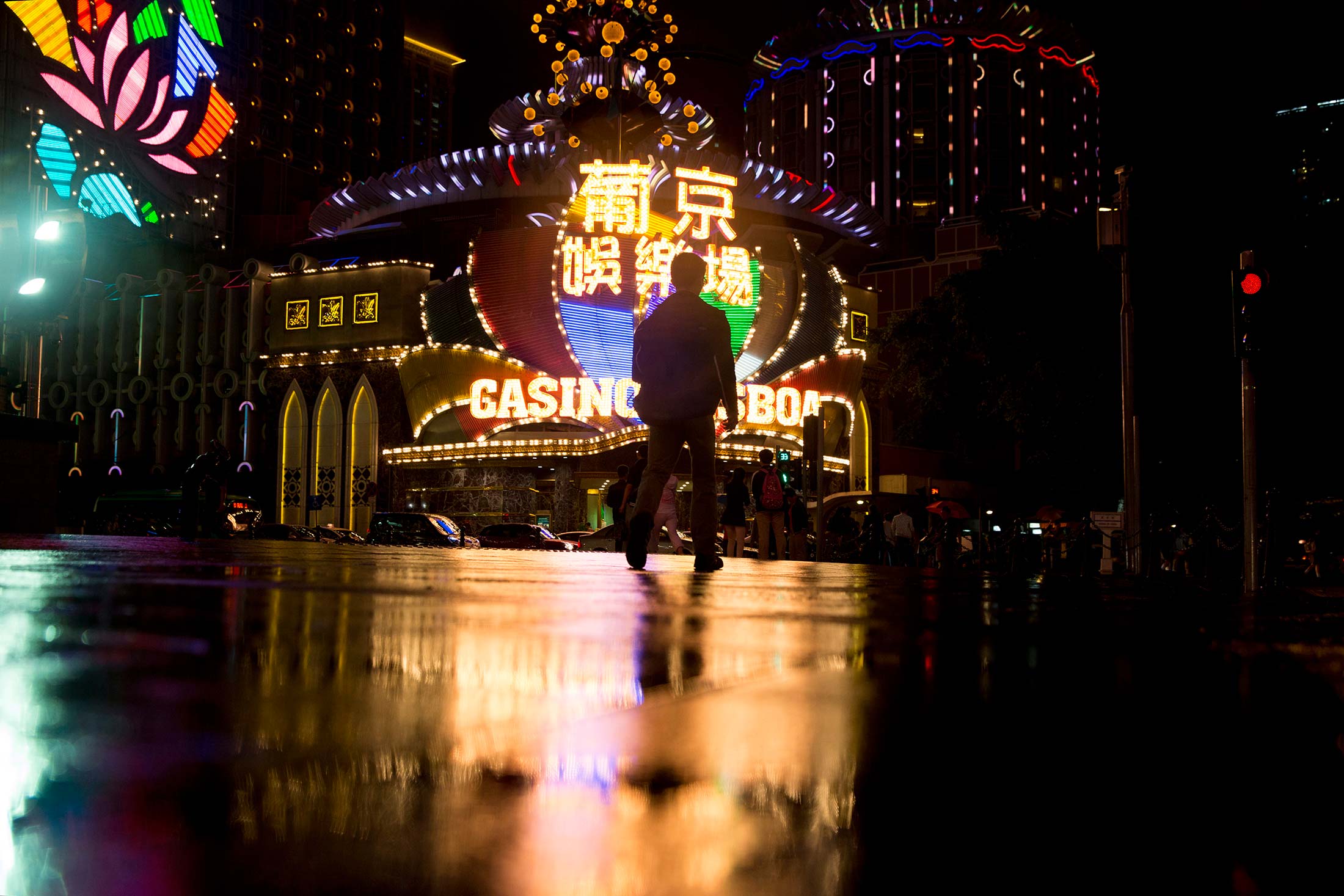 A man walks towards the Casino Lisboa, operated by SJM Holdings, illuminated at night in Macau, China, on May 8, 2014.

