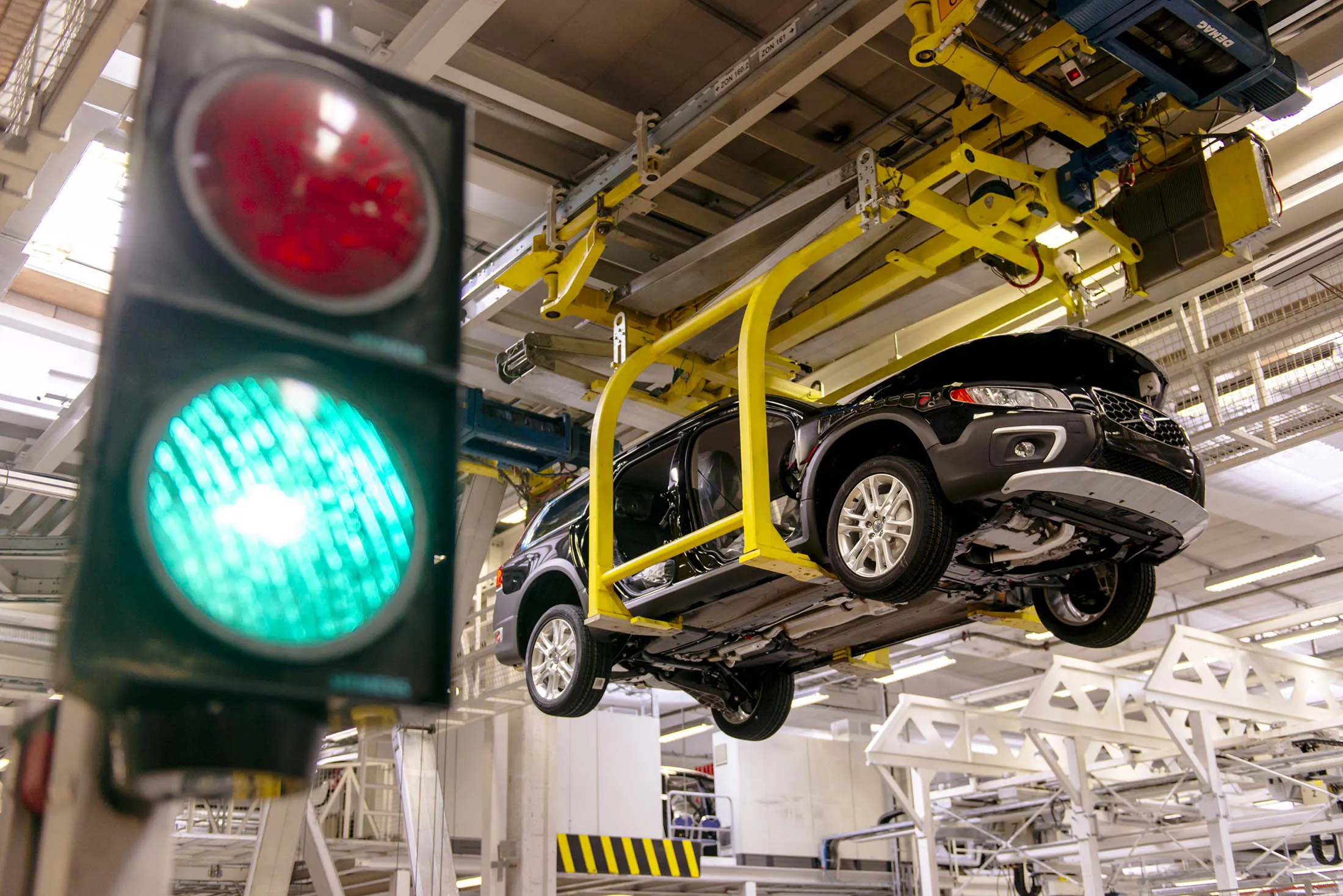 A vehicle hangs suspended from an overhead crane as it moves along the production line at the Volvo Cars plant in Torslanda, Sweden.
