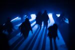 Mystic picture of silhouette of people walking at night with blue light.
