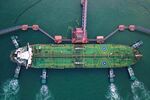 TOPSHOT - This aerial photo taken on August 4, 2019 shows tugboats berthing an oil tanker at Qingdao port in Qingdao in China's eastern Shandong province. - China's good shipments abroad beat expectations to rise in July while its purchases continued to shrink, official data showed on August 8. 