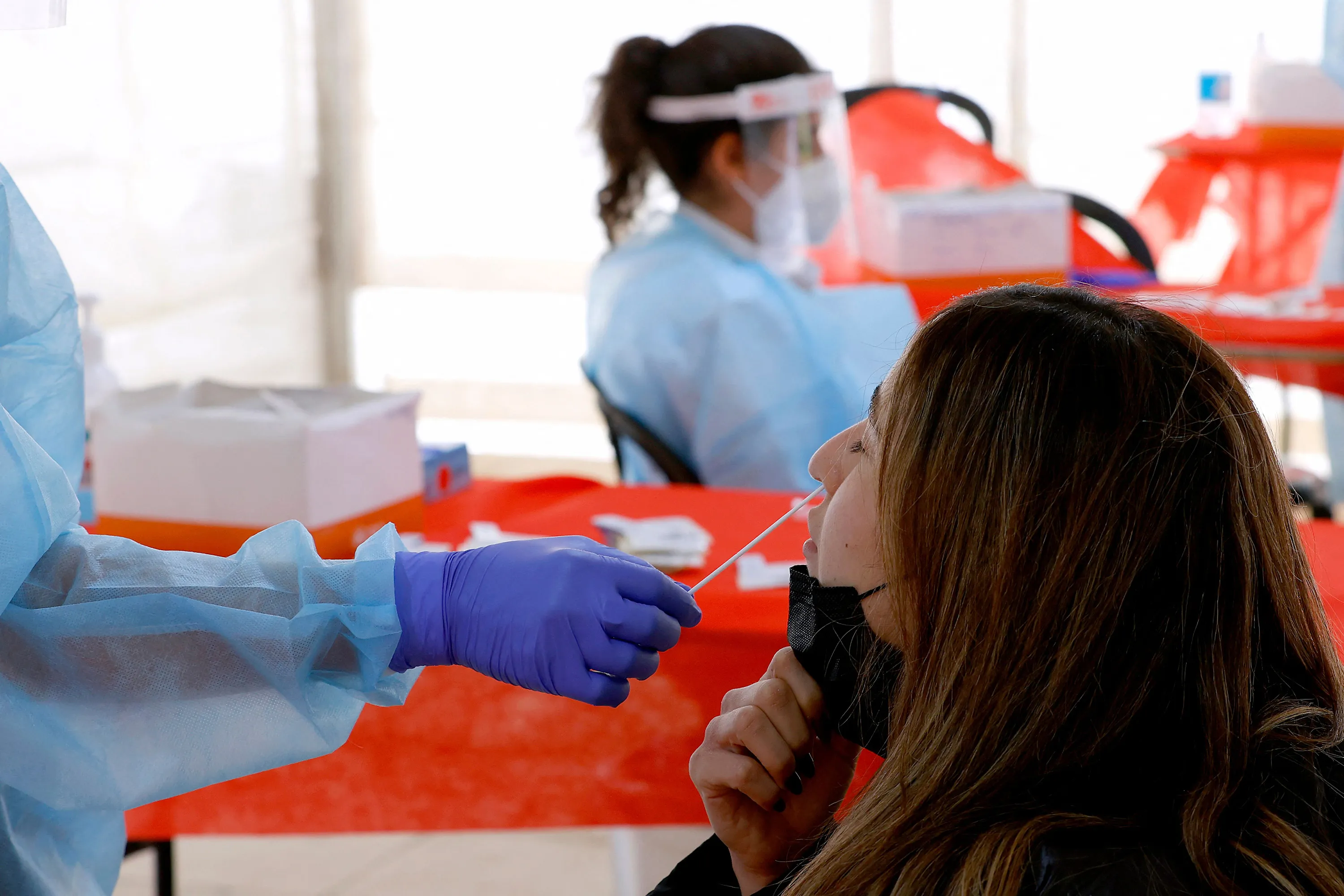 A paramedic collects a swab sample at a coronavirus testing center in Tel Aviv, Israel.