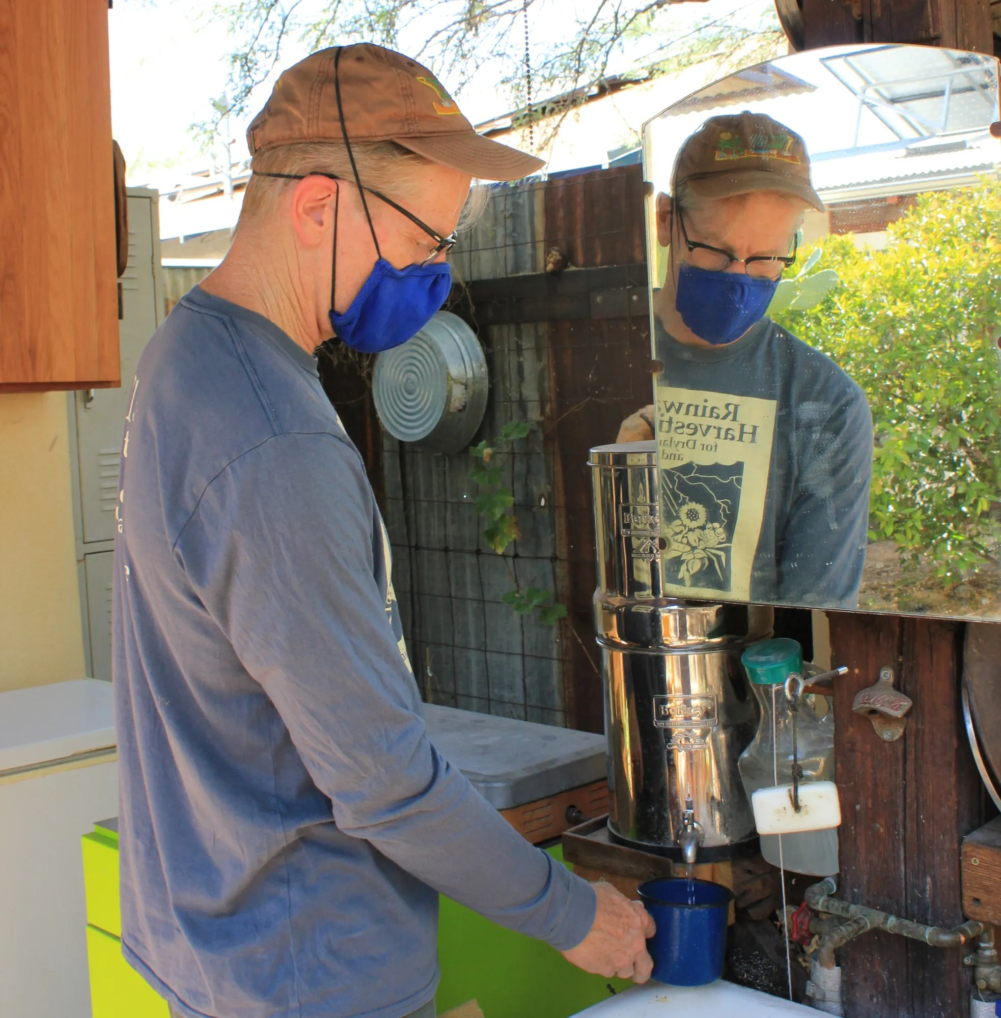 Brad Lancaster, a water harvesting activist, fills a cup with filtered rainwater collected from his roof.