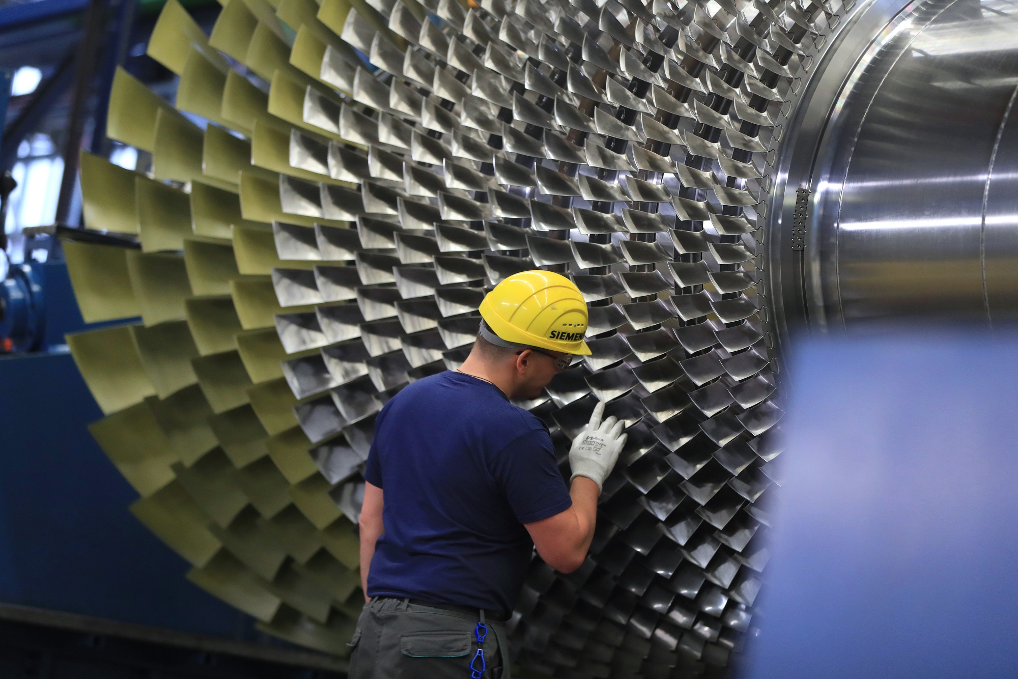 A worker checks the blades of a SGT5-4000F gas turbine inside a Siemens AG gas turbine factory in Berlin, Germany, on Wednesday, Dec. 4, 2019. Siemens AG aims to shed about 75% of its struggling power and gas unit in one of the most radical moves to date by Chief Executive Officer Joe Kaeser to untangle the sprawling conglomerate and try to boost its valuation. Photographer: Krisztian Bocsi/Bloomberg