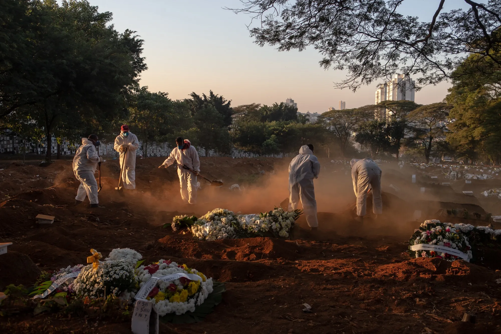 Workers wearing protective equipment bury the casket of a Covid-19 victim at the Vila Formosa cemetery in Sao Paulo, Brazil, on&nbsp;May 29.