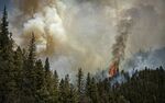 Fire rages along a ridgeline east of highway 518 near the Taos County line as firefighters from all over the country converge on Northern New Mexico to battle the Hermit's Peak and Calf Canyon fires on May 13, 2022. (Jim Weber/Santa Fe New Mexican via AP)