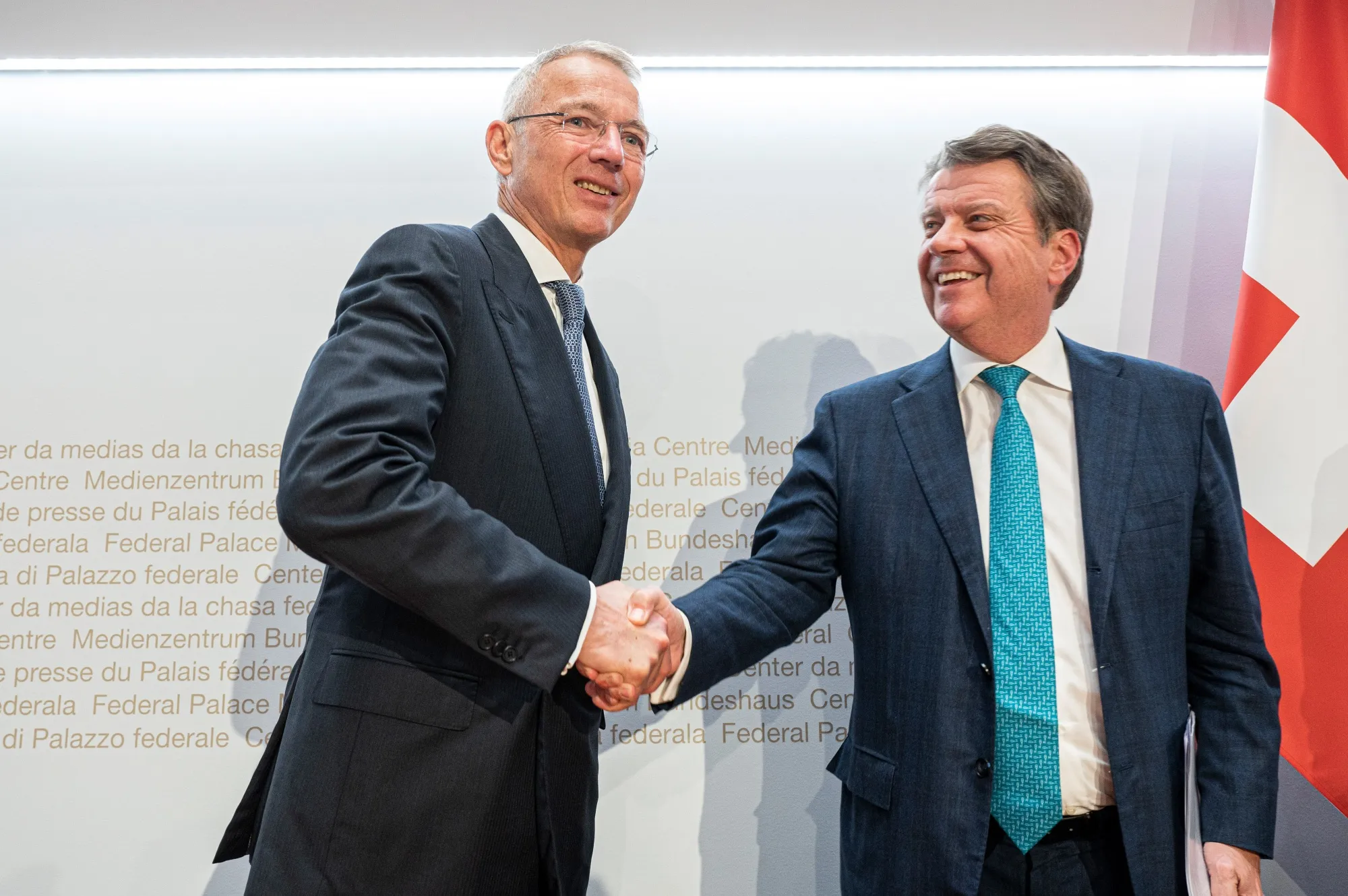 Axel Lehmann, chairman of Credit Suisse, left, and Colm Kelleher, chairman of UBS, shake hands following a news conference in Bern, Switzerland, on Sunday.