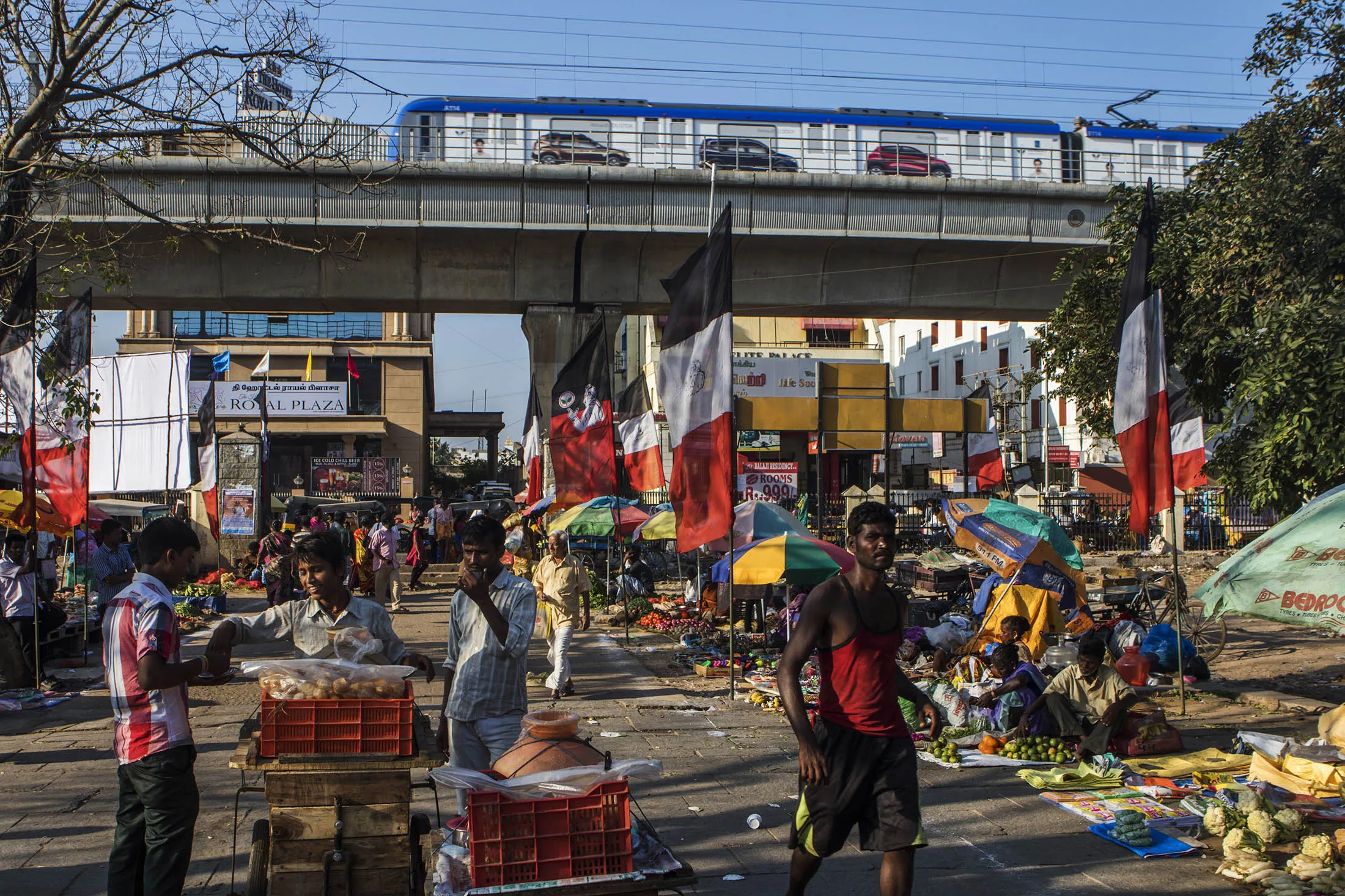 Shoppers and pedestrians walk past fruit and vegetable stalls at a street market in Chennai, Tamil Nadu, India, on Thursday, Feb. 25, 2016. India must review its fiscal deficit targets in the coming years, Finance Minister Arun Jaitley's advisers said in a report before he presents the annual budget.
