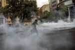 A protester runs as tear gas is fired during a protest in Santiago, Oct. 21.