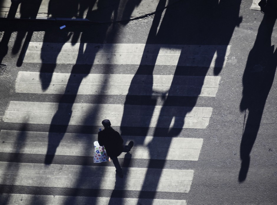 A lone pedestrian carries a shopping bag across a street in Times Square in New York.