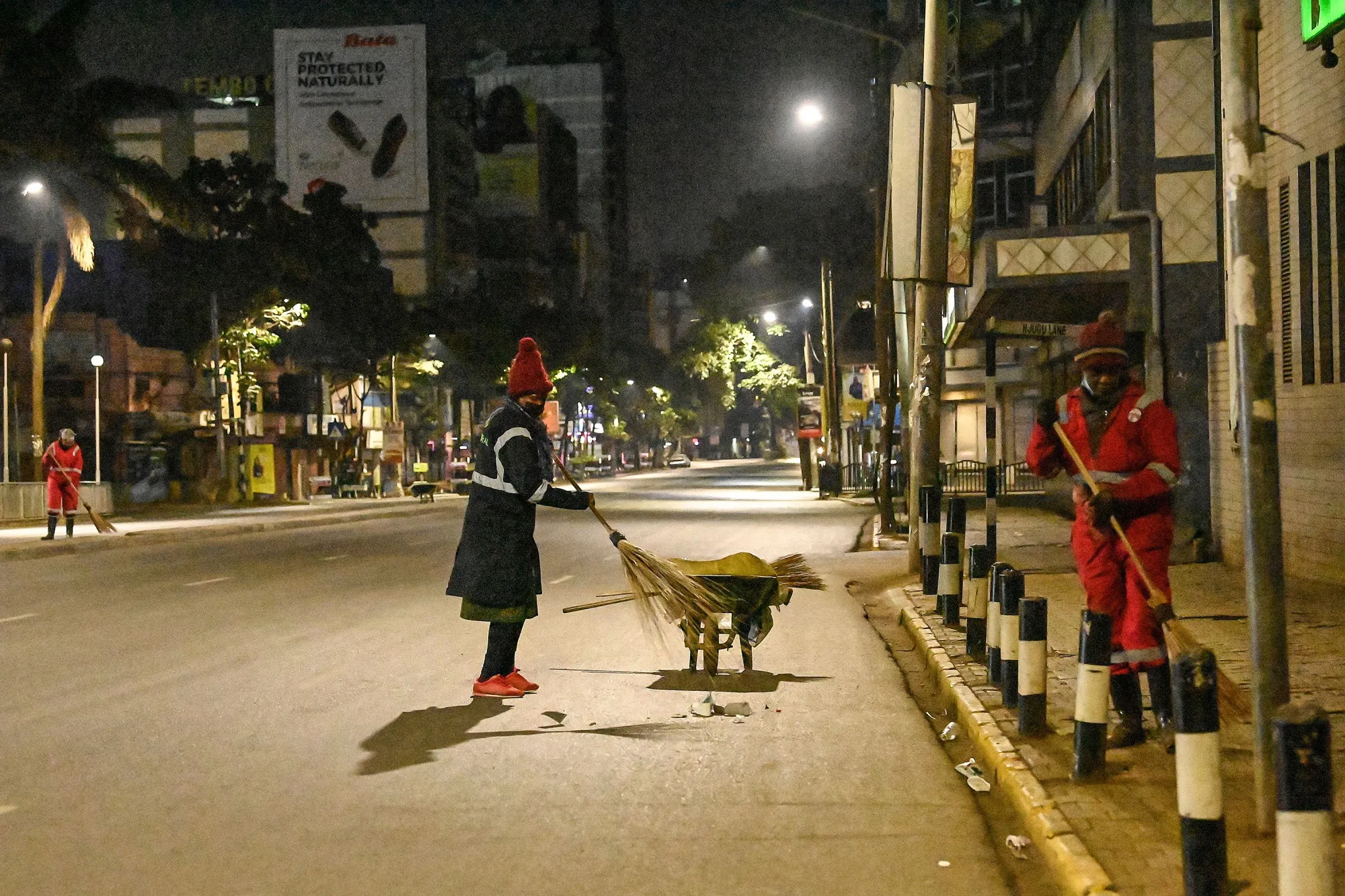 County workers clean the empty streets during a curfew in Nairobi.