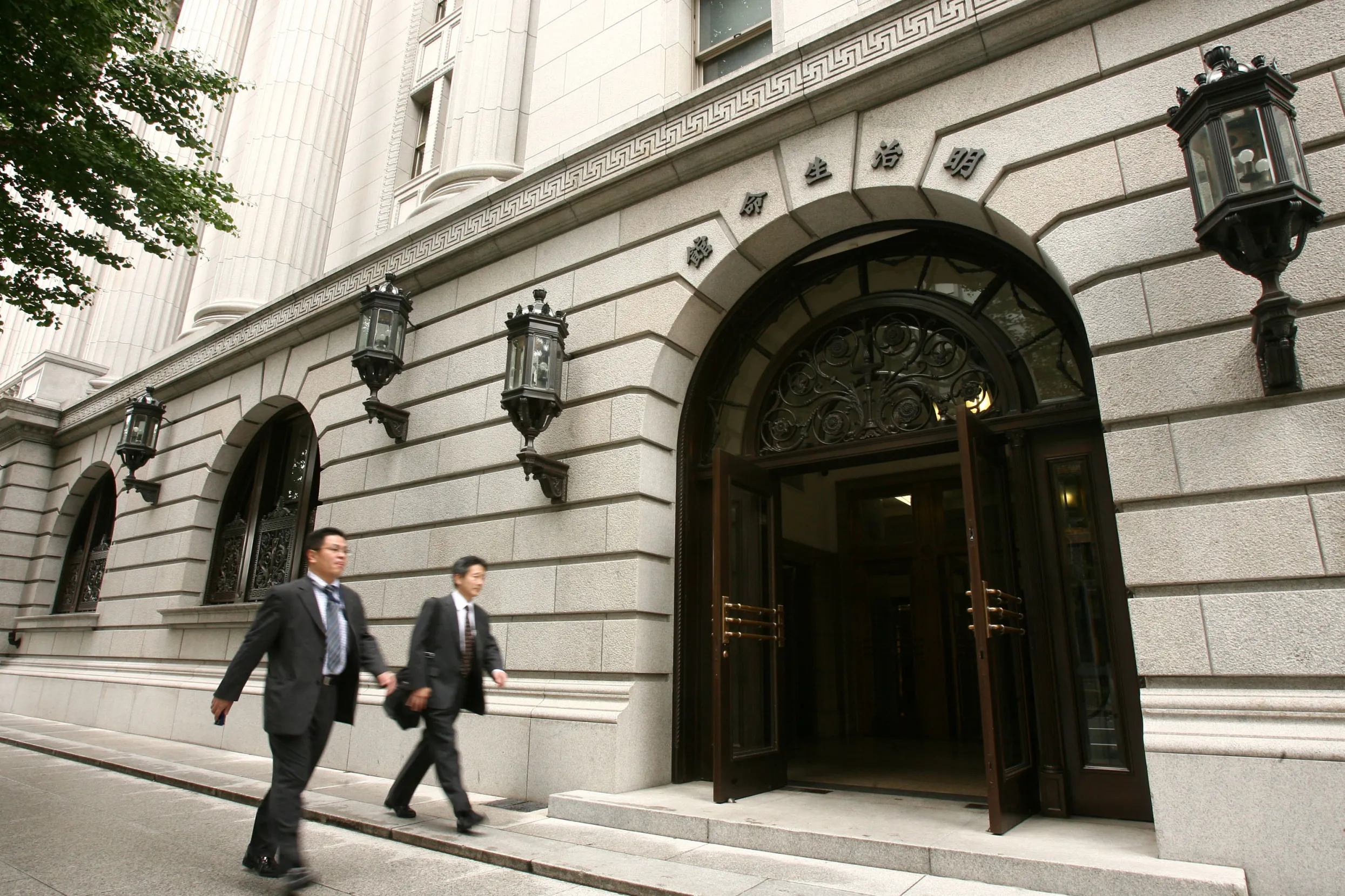 Pedestrians walk past the Meiji Yasuda Life Insurance Co. headquarters in Tokyo, Japan.