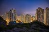 Residential buildings stand illuminated at dusk in Hong Kong, China, on Saturday, July 21, 2018. Hong Kong's property market has a habit of humbling the bears, shattering predictions that the laws of gravity must eventually prevail.