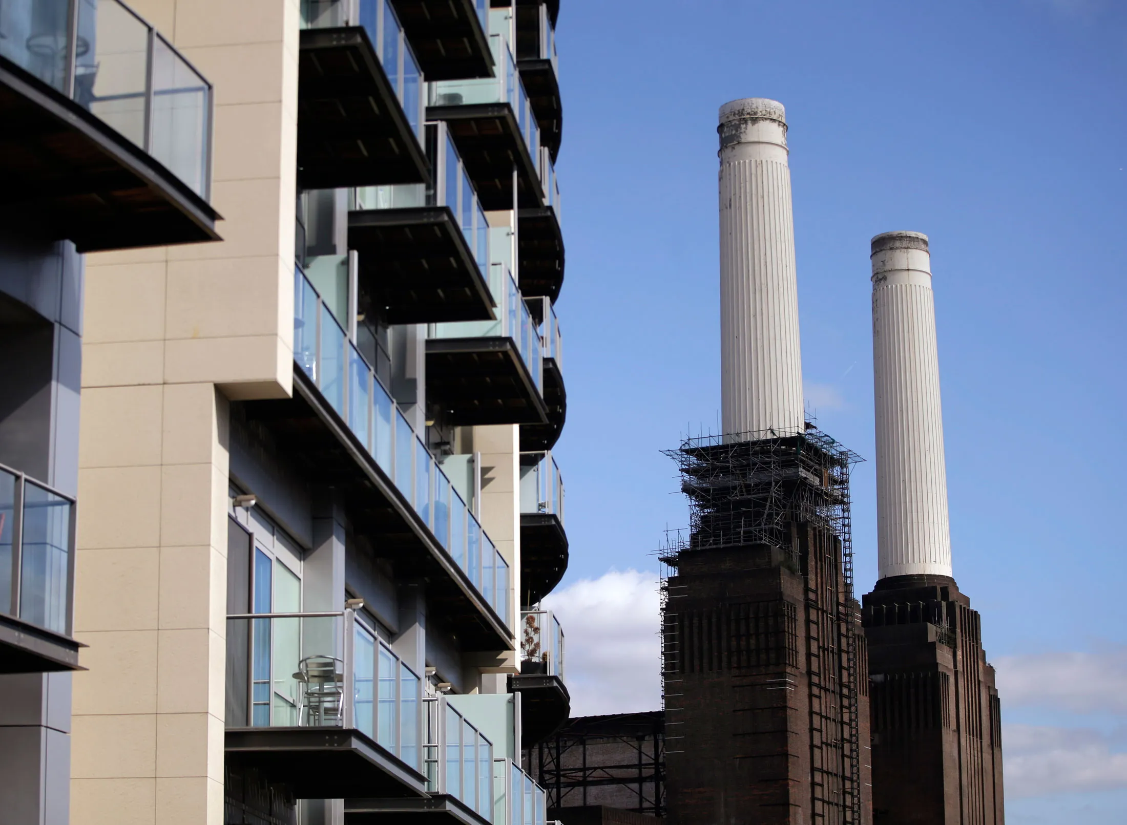 Balconies sit in front of residential apartments as scaffolding stands around one of the chimneys of Battersea power station in London, U.K. on Friday, Sept. 20, 2013.
