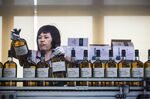 An employee boxes bottles of single malt scotch whisky at the Diageo International Supply Center in Singapore.
