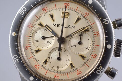 A closer look at the red printing and arrow-shaped markers on the Meylan dial.