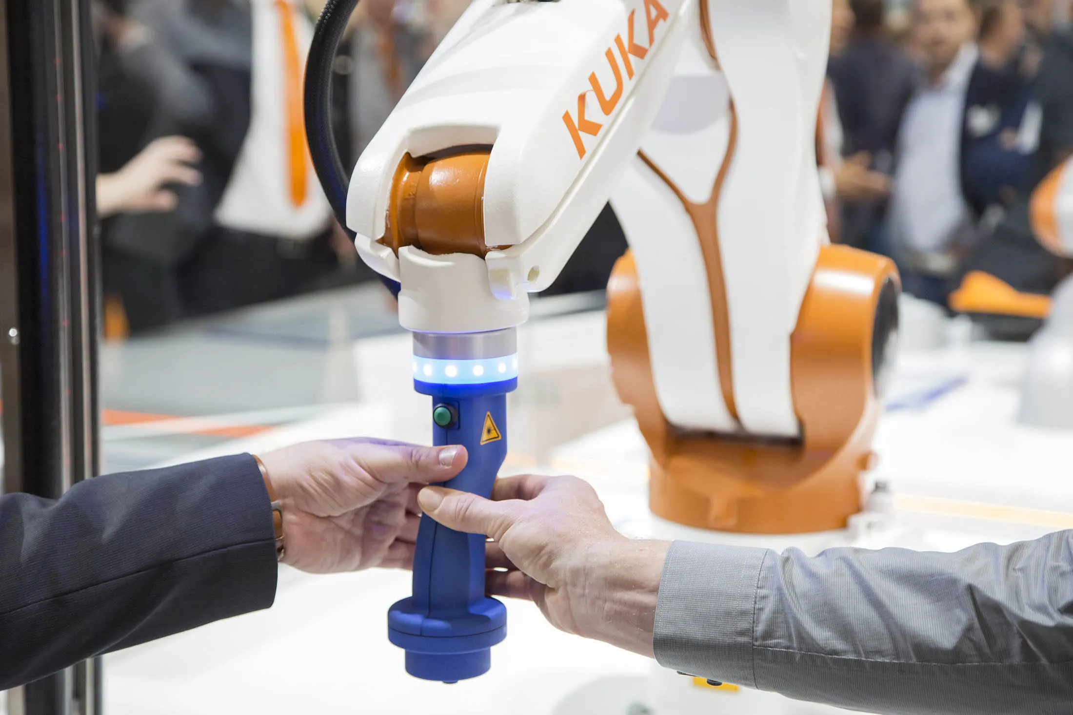 Attendees inspect a robotic arm at the Kuka exhibition stand during the Automatica trade fair in Munich.
