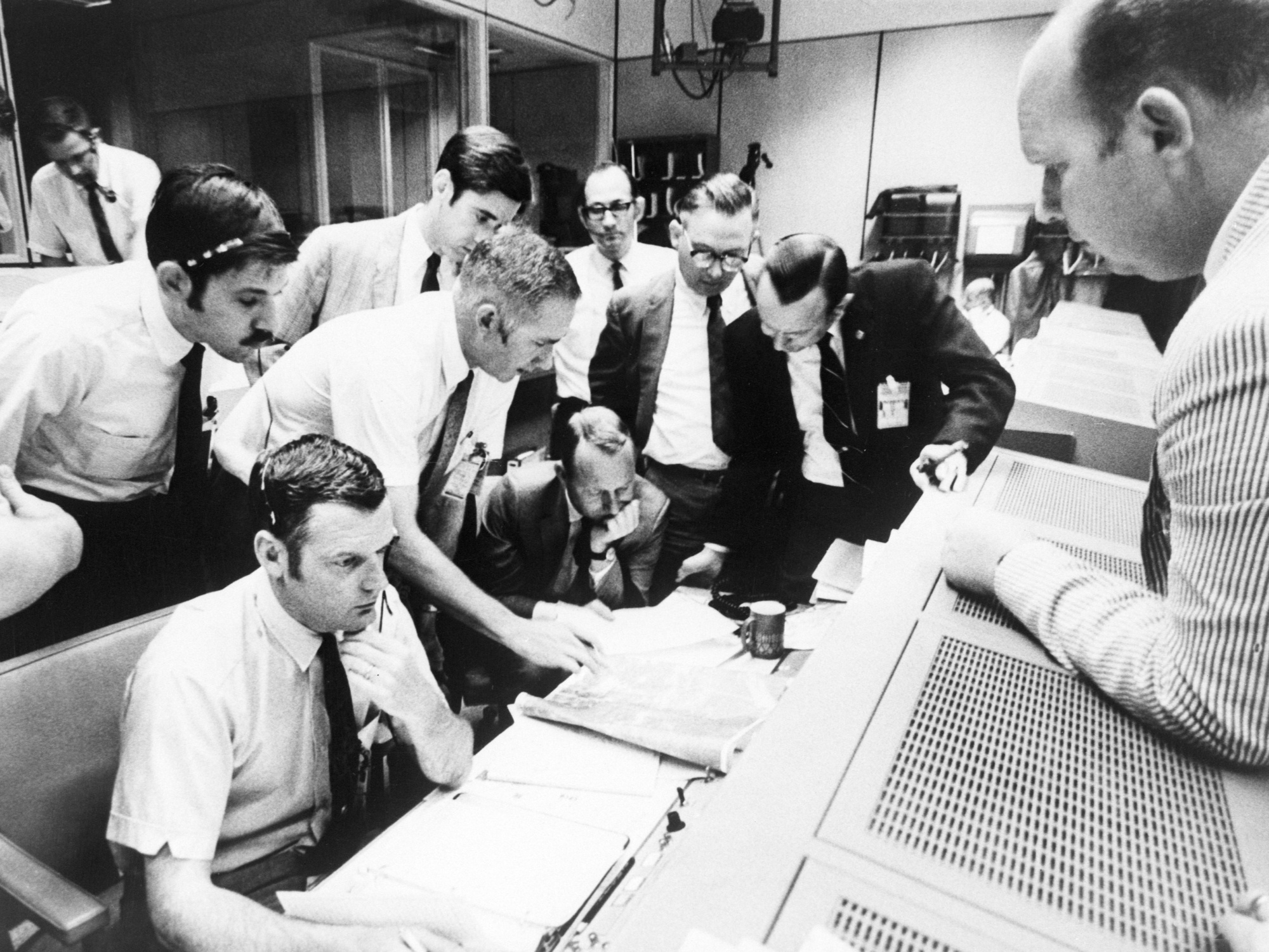 Glynn Lunney, seated at left, consulting with Apollo 13 flight controllers.