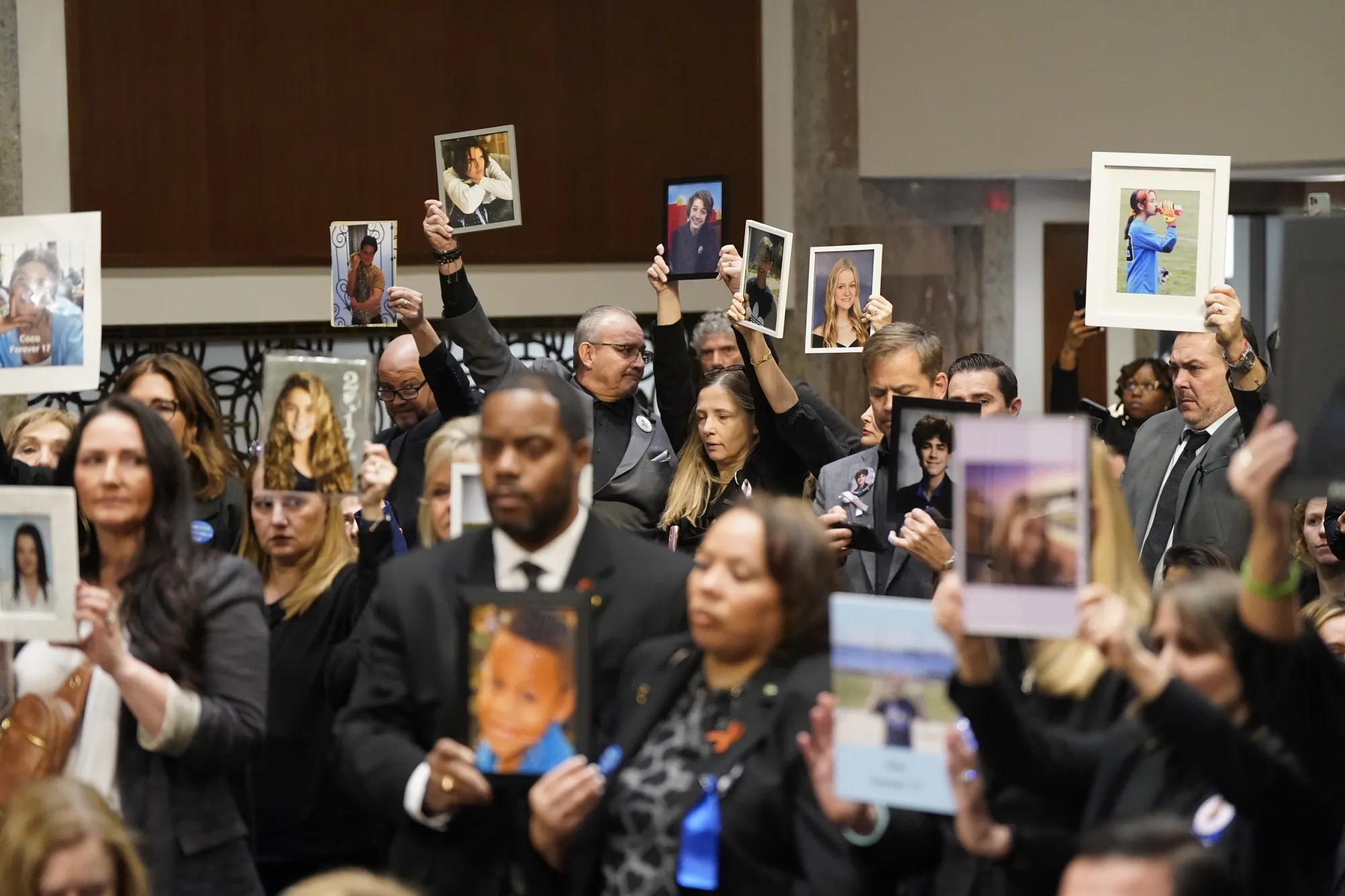 Families of children who were victims of sexual exploitation on social media platforms hold photos at&nbsp;a US Senate Judiciary Committee hearing in January.