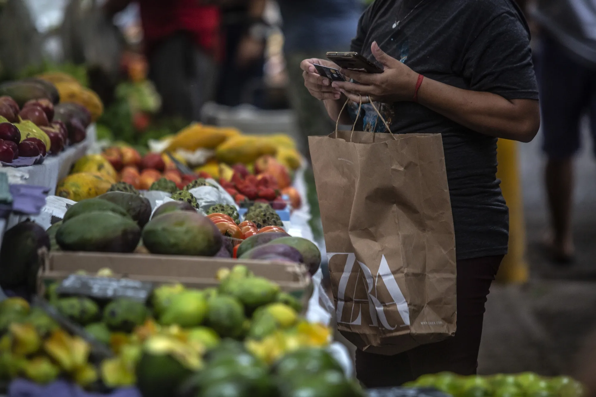 A shopper browses fresh fruits and vegetables at a street market in the Ipanema neighborhood of Rio de Janeiro.