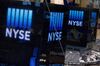 The New York Stock Exchange (NYSE) logo is displayed above the trading floor in New York, U.S., on Tuesday, June 24, 2014. U.S. stocks rose, with equity benchmarks trading near all-time highs, as data showing a gain in consumer confidence and a surge in sales of new homes boosted optimism about growth in the world’s largest economy.