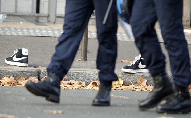 Police pass a pair of abandoned shoes seen left in the street near the Bataclan concert hall the morning after a series of deadly attacks in Paris. 