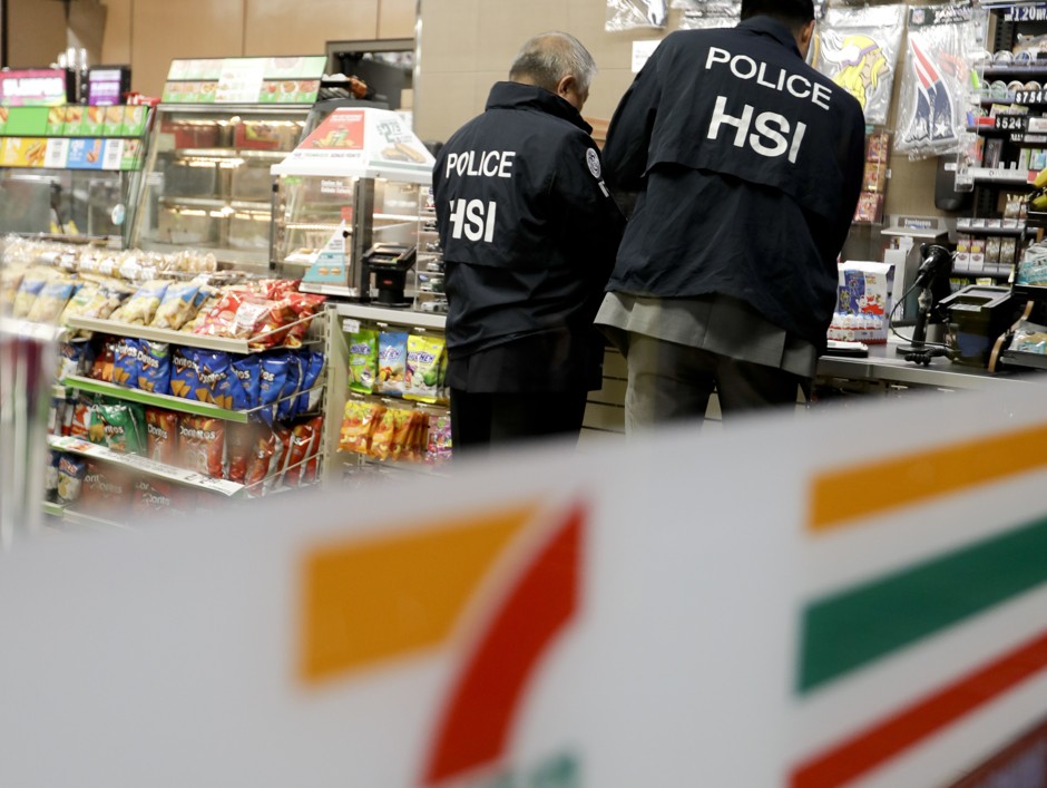 U.S. Immigration and Customs Enforcement agents serve an employment audit notice at a 7-Eleven convenience store. 