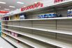 A nearly empty baby formula display shelf is seen at a
