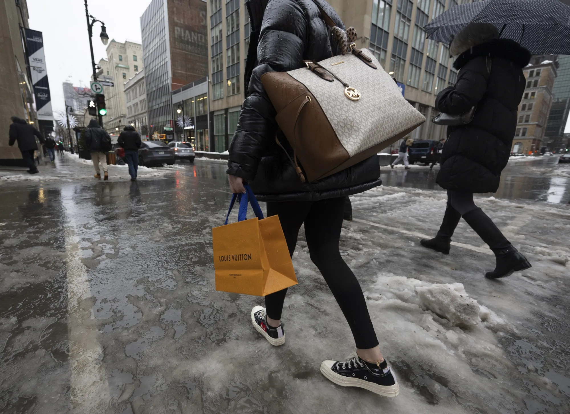 Shoppers walk through slush during a winter storm in Montreal, Quebec, Canada.