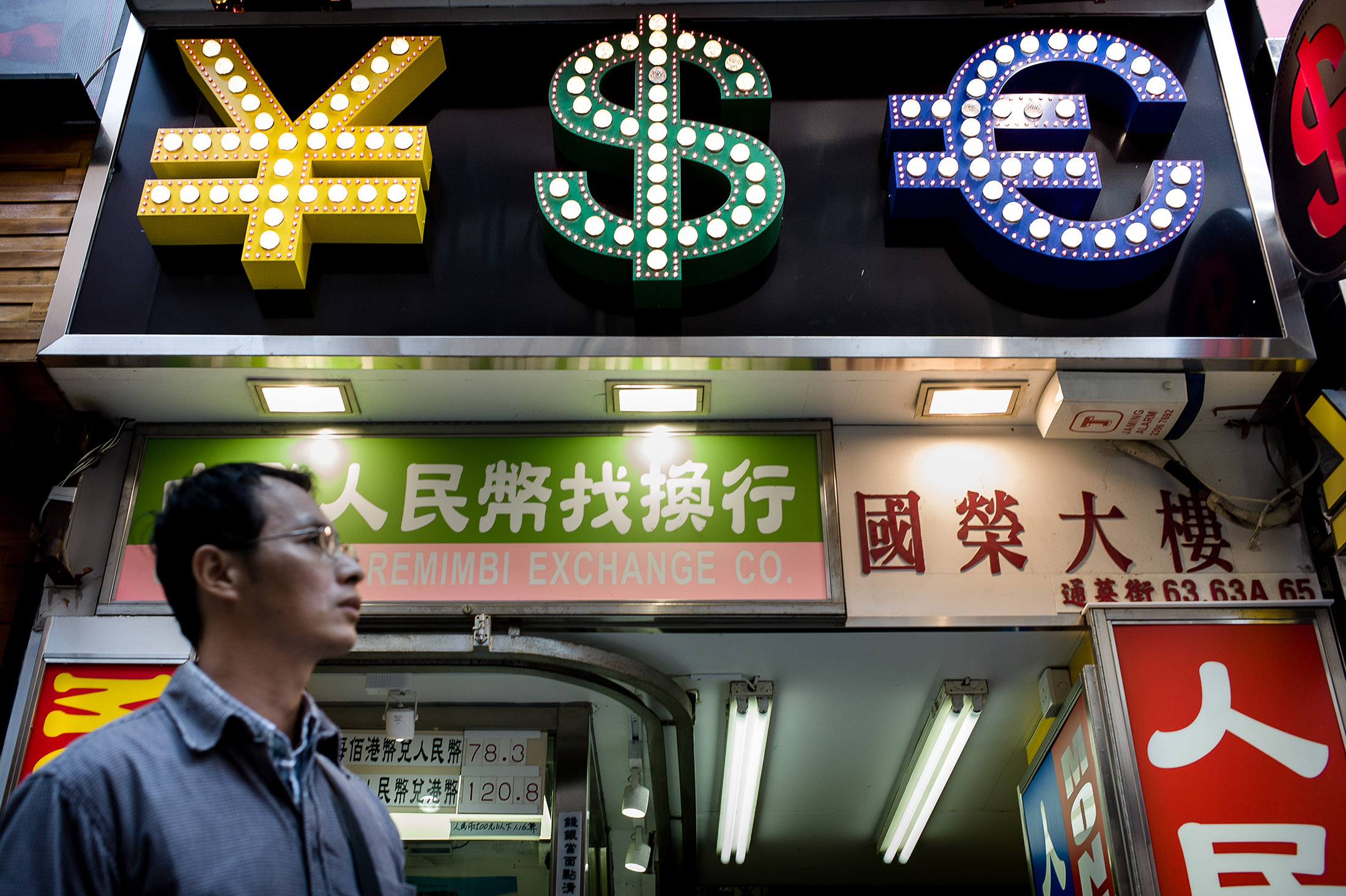 A man walks past a money exchange booth in Hong Kong.
