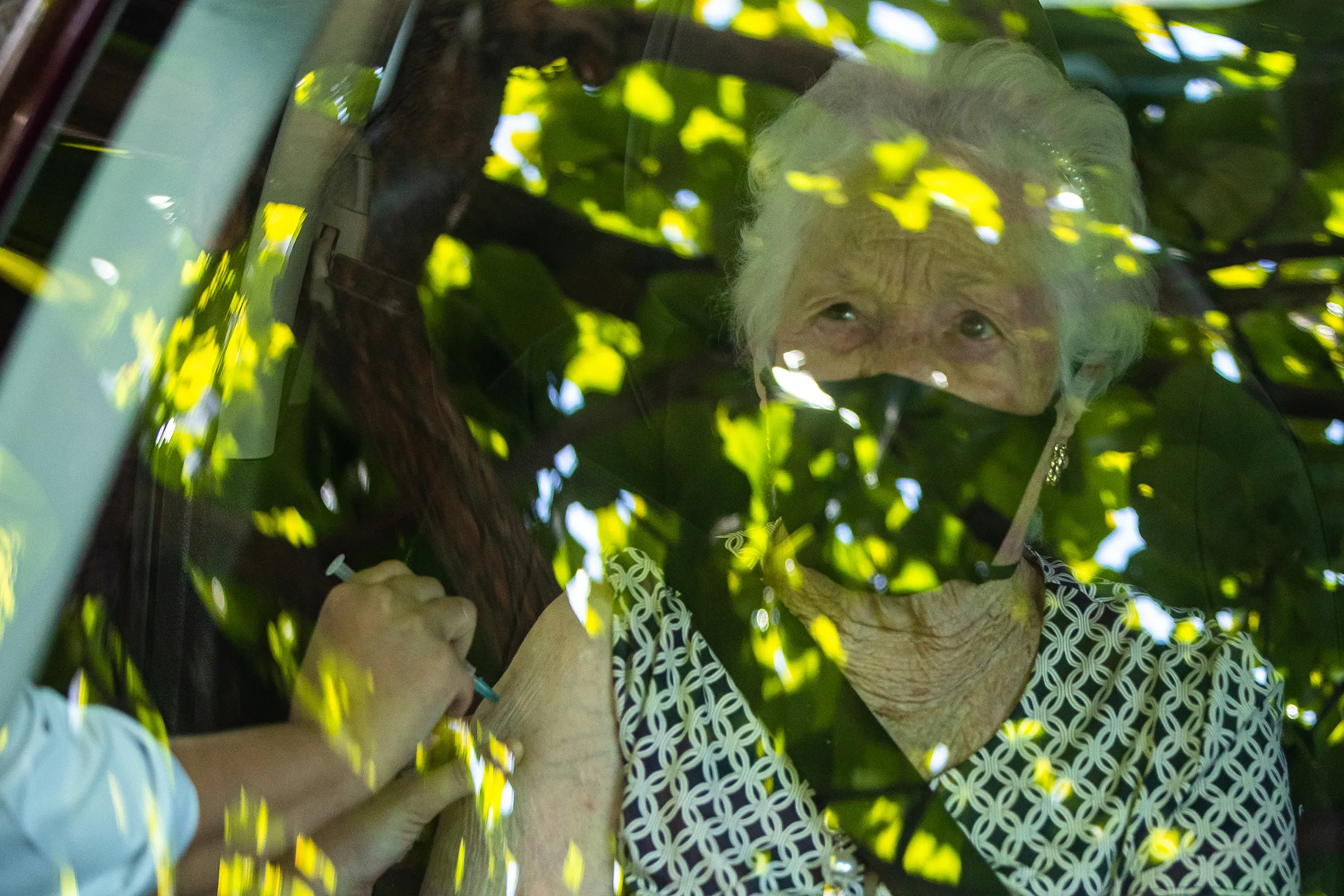A senior receives the Covid&nbsp;vaccination shot at a drive-thru post.