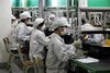 Employees work on the assembly line at Hon Hai Group's Foxconn plant in Shenzhen, Guangdong province, China, on Wednesday, May 26, 2010. Terry Gou, founder and chairman of Hon Hai Group, said nine of the 11 company workers who either committed suicide or attempted to had worked at the company less than a year, and six had been employed for less than a half-year.