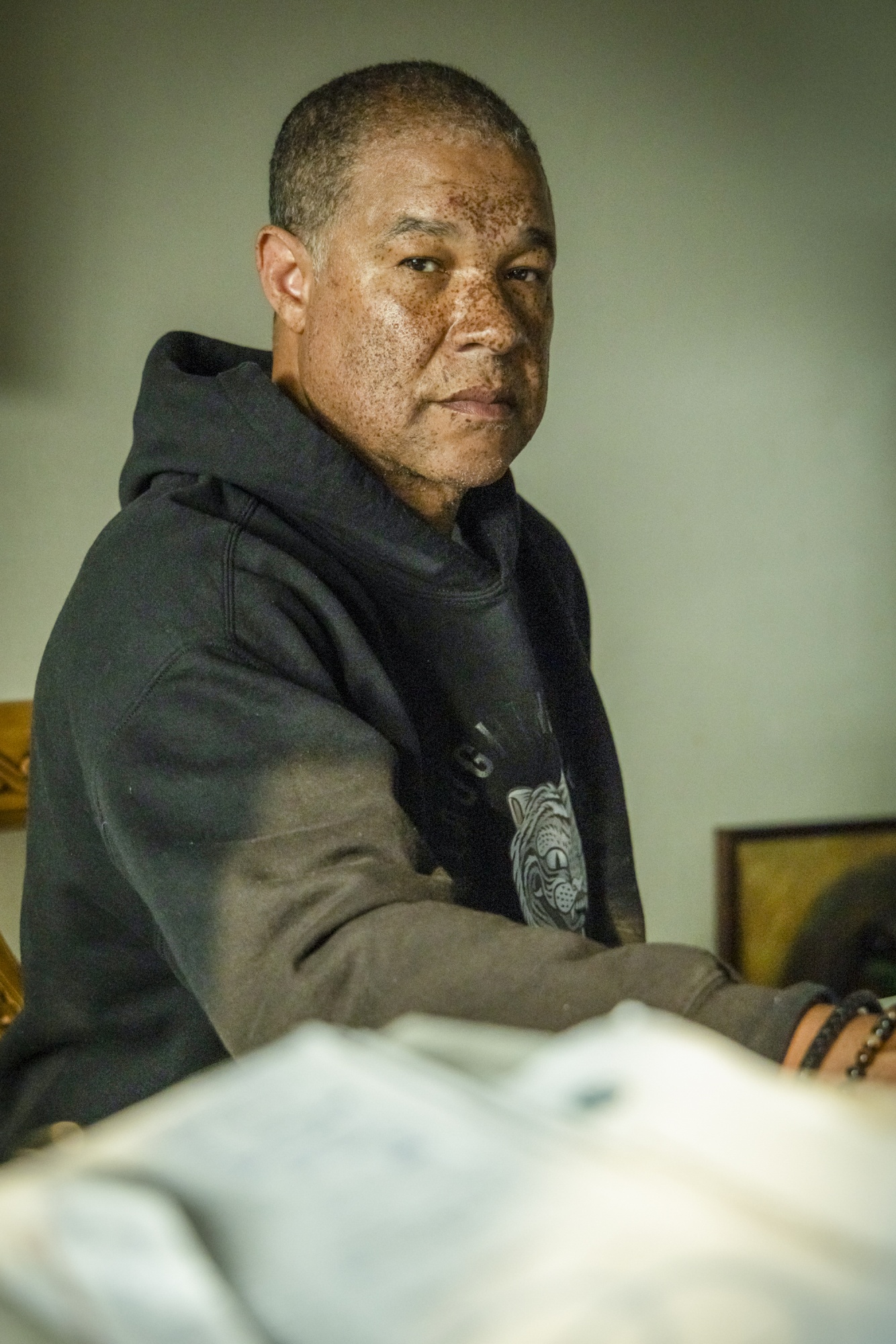 A photo of a man at his desk with paperwork in the foreground.