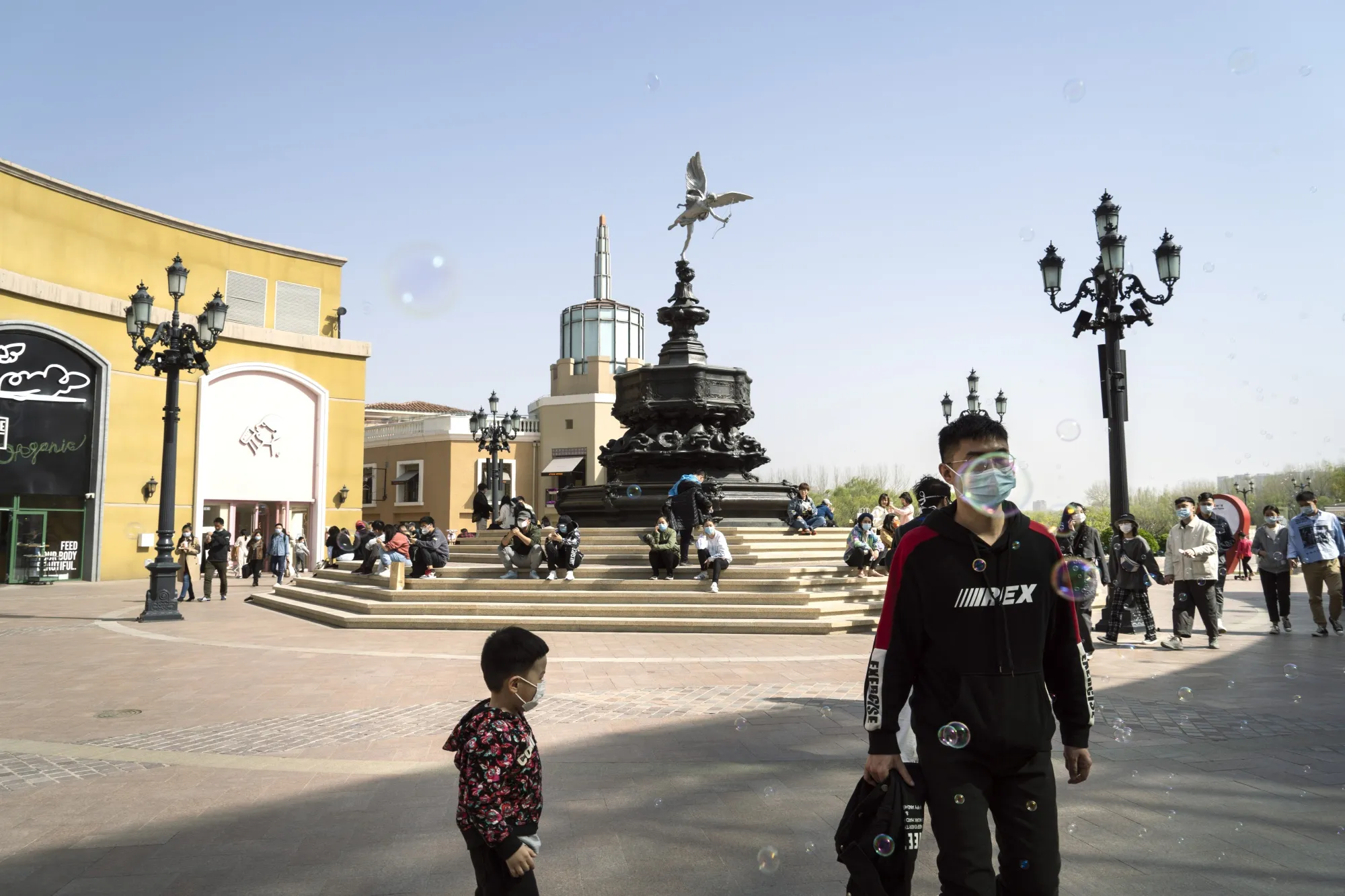Pedestrians wear protective face masks in a shopping area in Beijing on April 4.