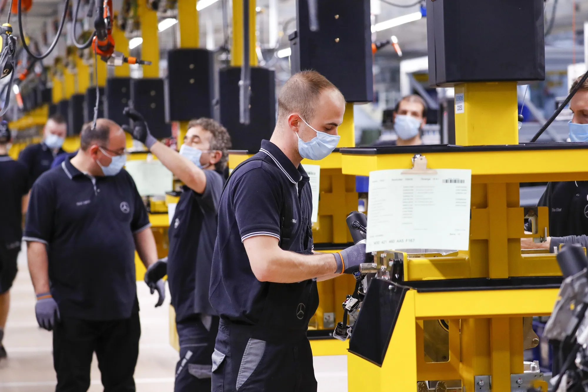 Employees operate&nbsp;production cradles at a factory in Stuttgart.