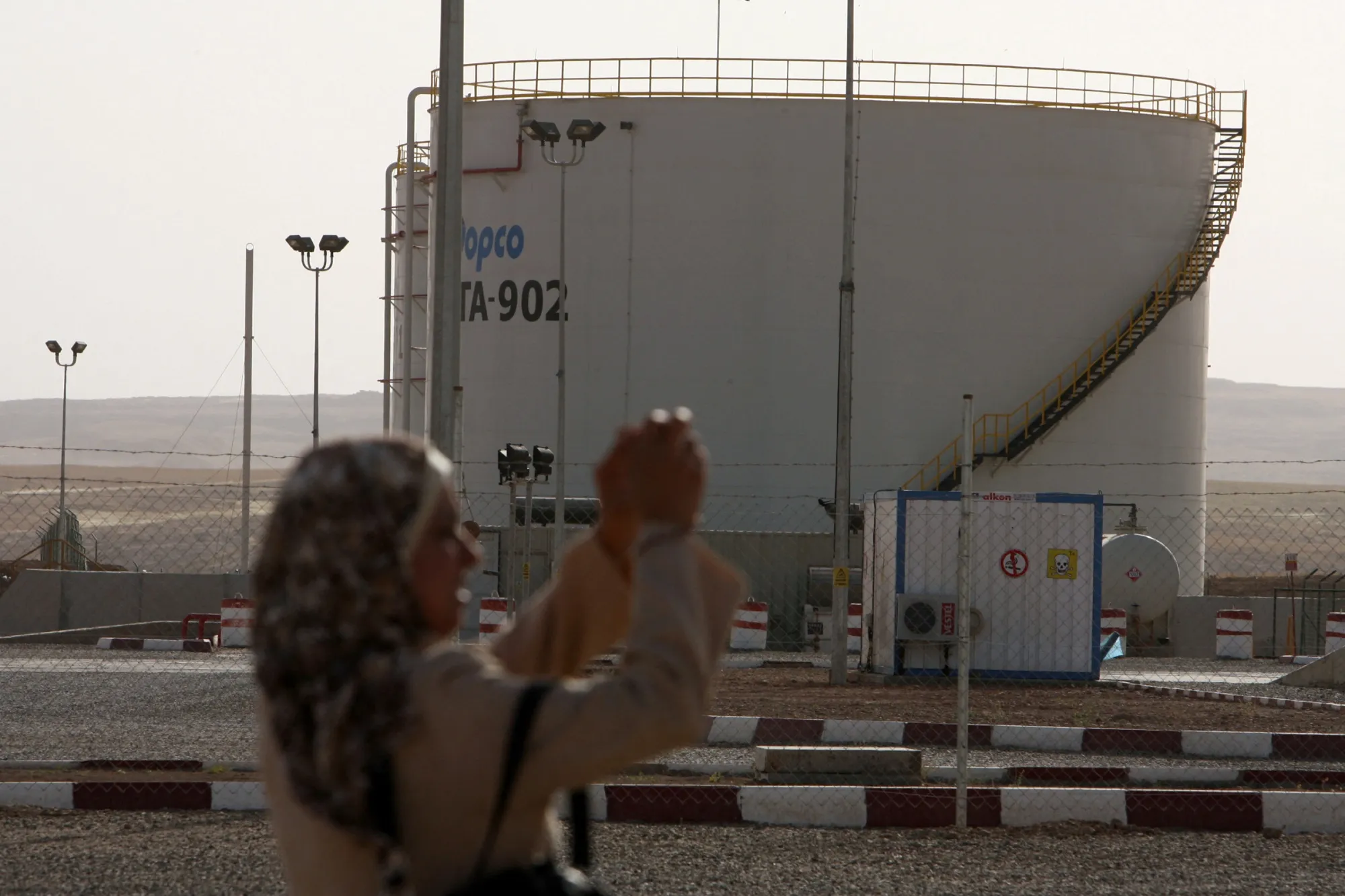 A woman takes a photograph at an oil refinery in the Kurdistan&nbsp;region of&nbsp;Iraq.