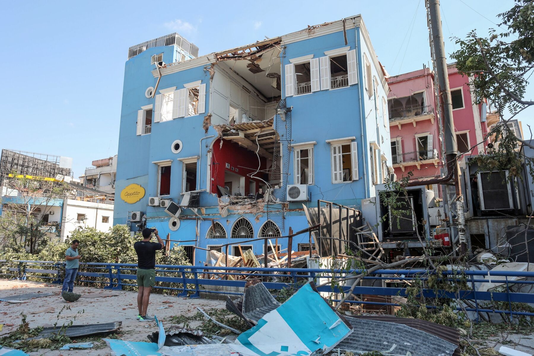 A pedestrian takes photos of a badly damaged building in Beirut, Lebanon, on Wednesday, Aug. 5, 2020. 