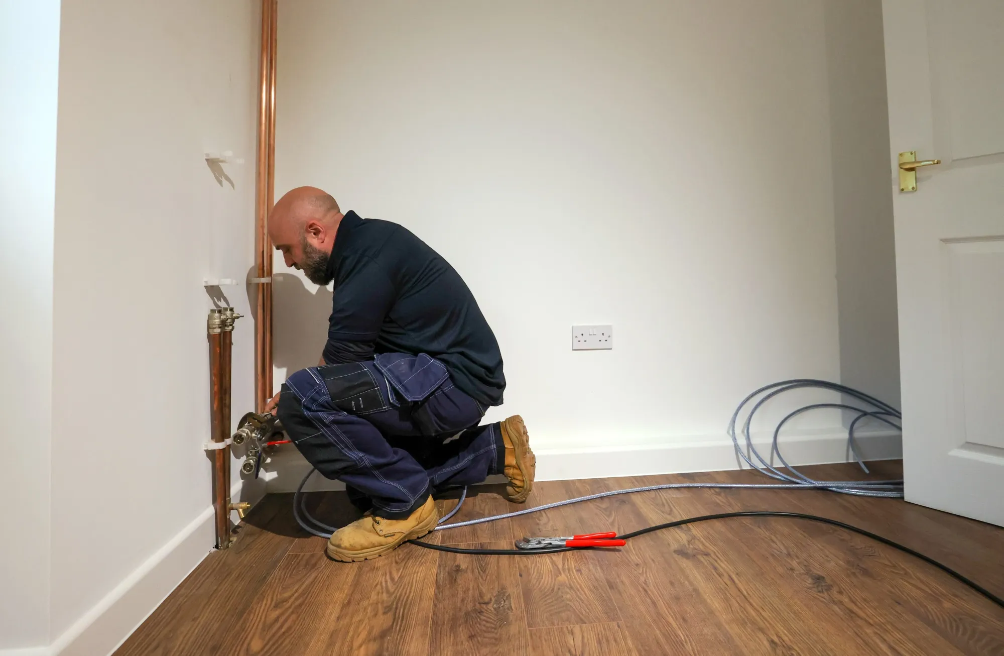 An engineer works on pipe&nbsp;installation for an external heat pump.