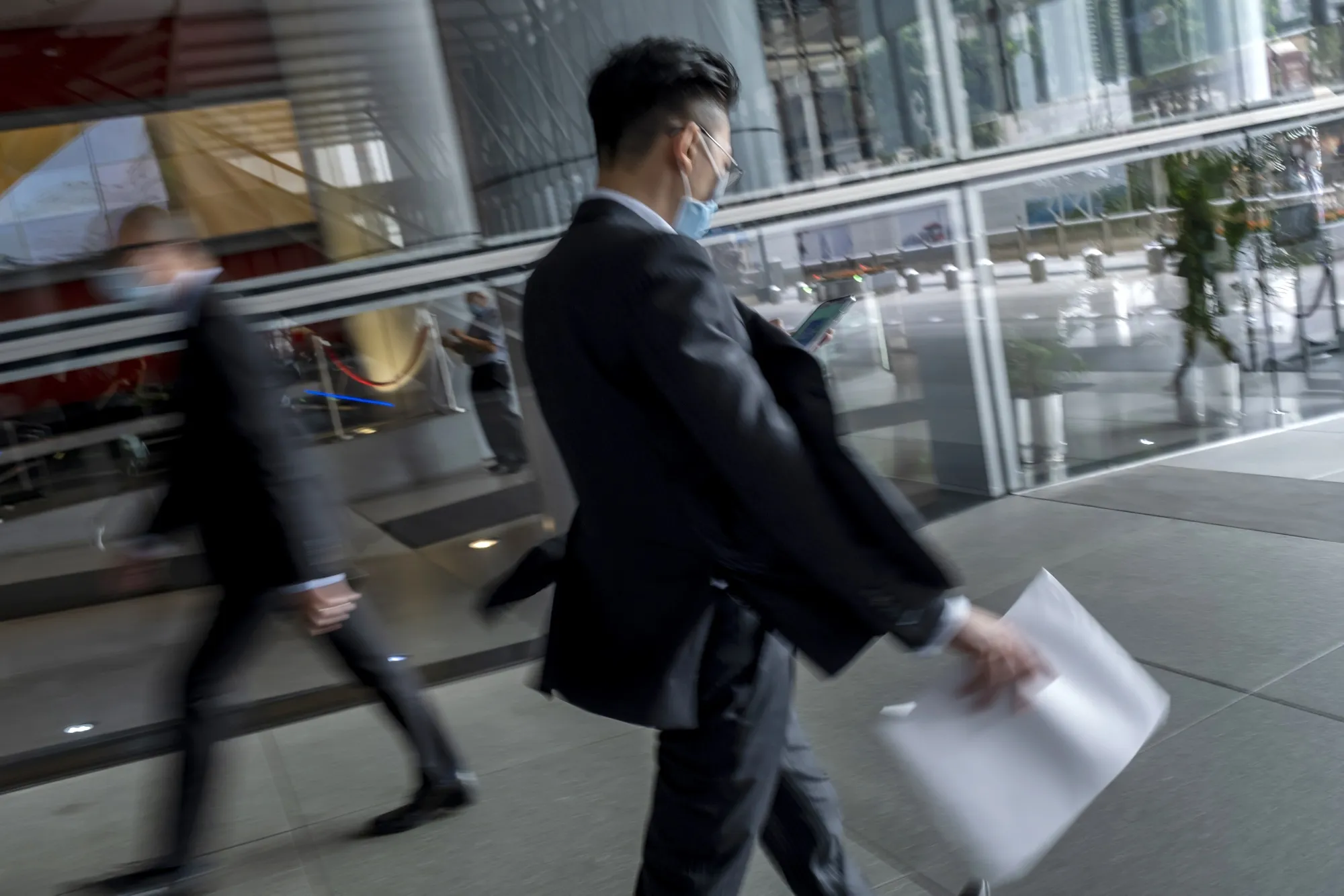 Commuters underneath the HSBC Holdings Plc headquarters building in the Central district of Hong Kong.