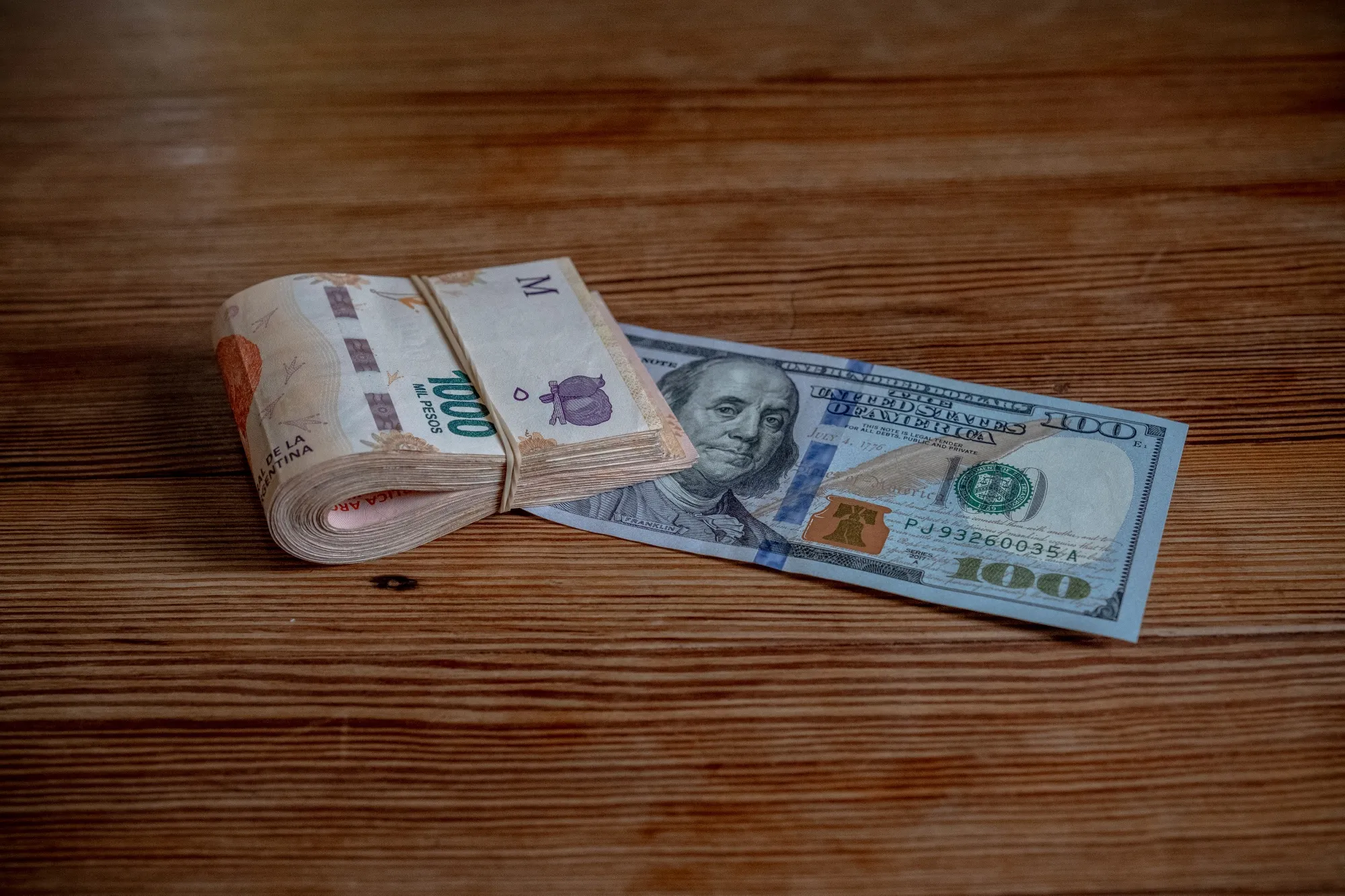 Billetes de pesos argentinos y dólar estadounidense.&nbsp;
