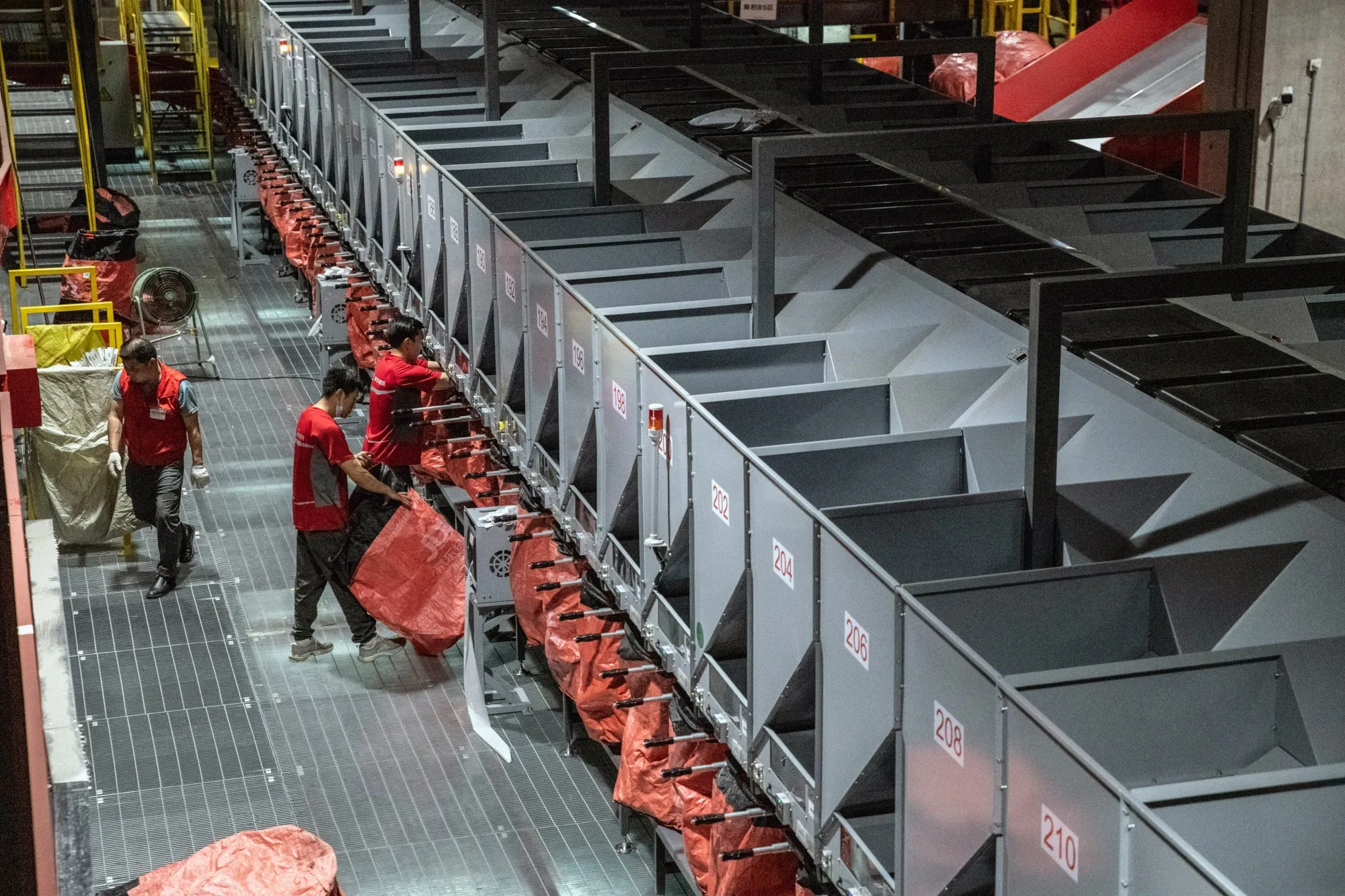 Employees sort packages at a JD.Com logistics facility in Kuchan, Jiangsu province, China.