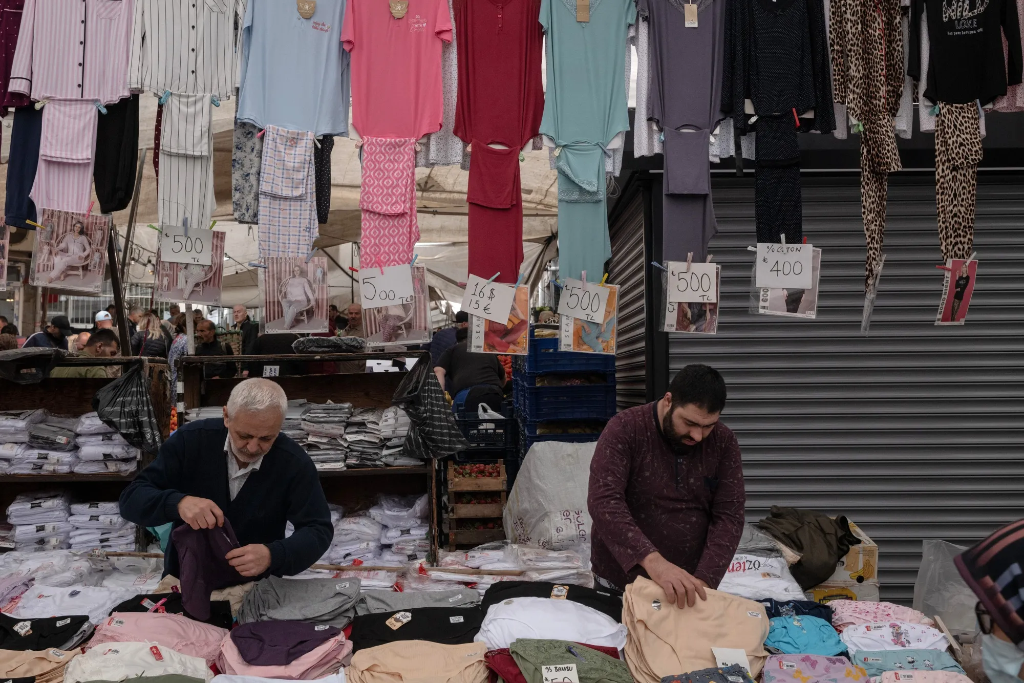 Vendors prepare clothing for sale at the Friday Bazaar market in Istanbul.