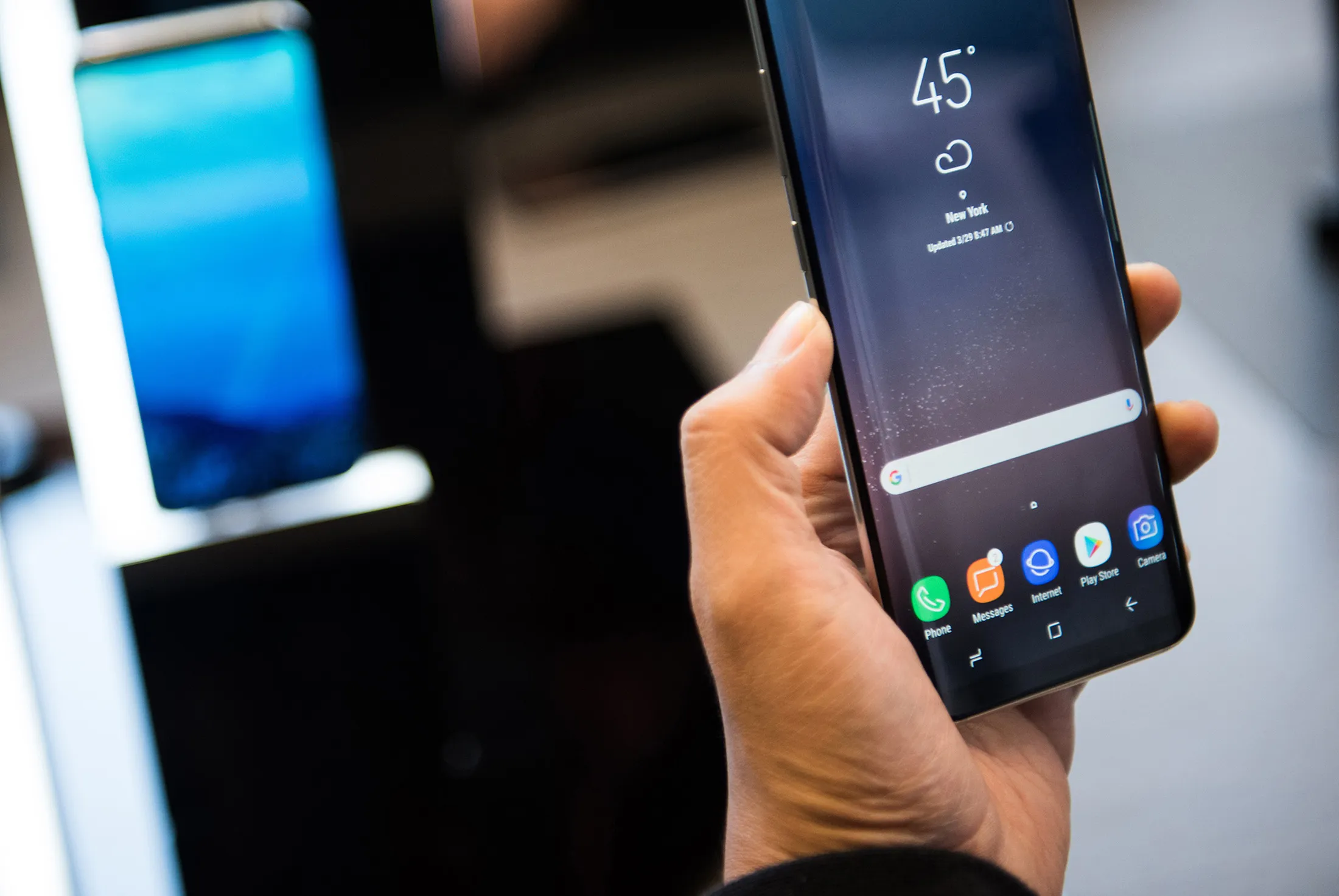 An attendee views the Samsung Electronics Co. Galaxy S8 smartphone displayed during the Samsung Unpacked product launch event in New York, U.S., on Wednesday, March 29, 2017. Samsung Electronics Co. packed the Galaxy S8 smartphone with a plethora of new features: taller, curved screens, encrypted facial recognition, deeper display colors, system-wide voice control and the ability to turn into a desktop computer.

